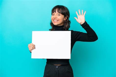 Joven Latina Aislada De Fondo Azul Sosteniendo Un Cartel Vac O Y Saludando Foto Premium