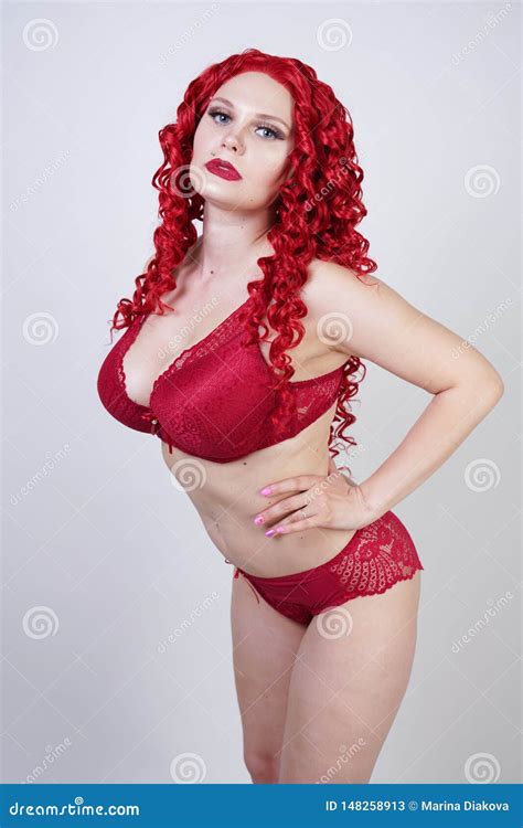 Hot Curvy Girl With Red Curly Hair Wearing Lace Lingerie And High Heels In The Studio Stock