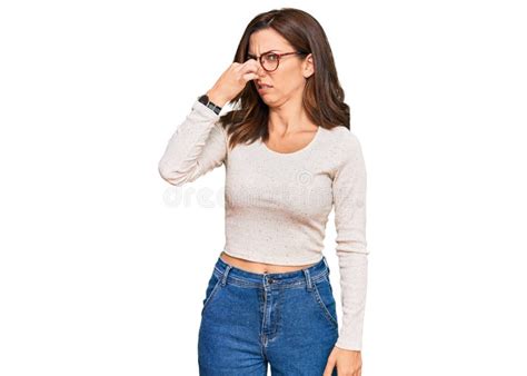 Young Brunette Woman Wearing Casual Clothes And Glasses Smelling