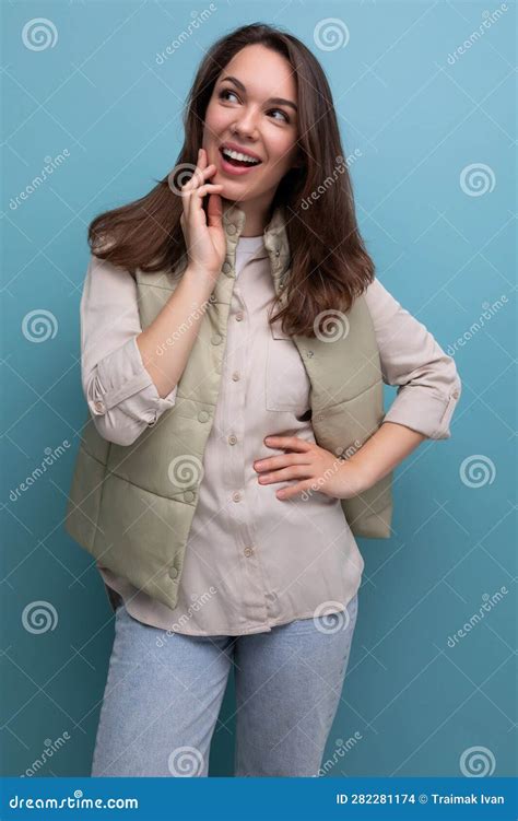 Jovencita De Brunette Sorprendida Con Ropa Informal En El Fondo Del Estudio Foto De Archivo