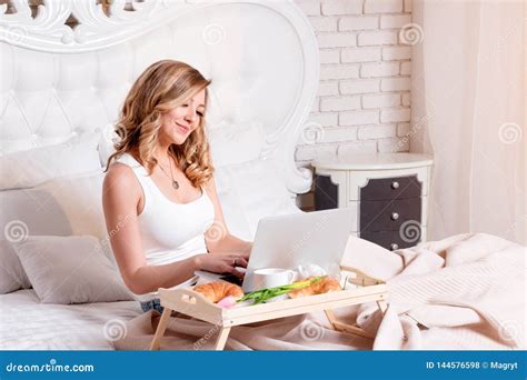 Junge Hübsche Blonde Frau Zu Hause Auf Bett Mit Dem Laptop Hat Frühstück Freiberufler Oder