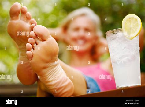 Close Up Of A Mature Woman S Foot With A Glass Of Lemon Juice Beside Stock Photo Alamy
