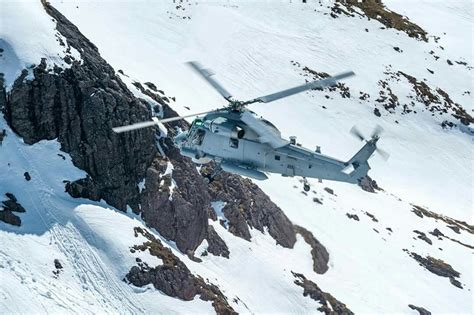 Helicopter Flying Over Snow Covered Mountain