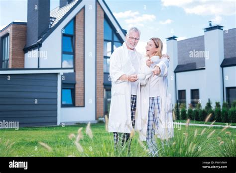 Blonde Haired Loving Wife Showing Her Husband Their New Plant In Courtyard Stock Photo Alamy