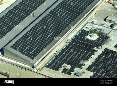 Aerial View Of Blue Photovoltaic Solar Panels Mounted On Industrial
