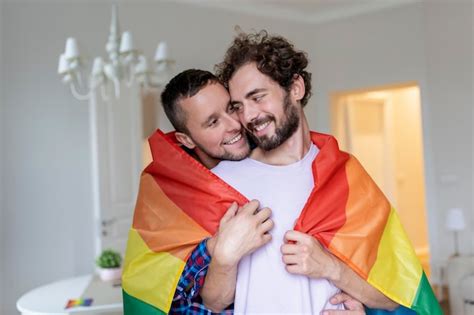 Casal gay masculino carinhoso dentro de casa Homem abraçando seu namorado por trás em casa Casal