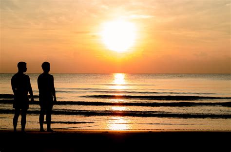 La Foto De La Silueta De La Pareja Gay De Pie Juntos En La Playa Foto De Stock En Vecteezy