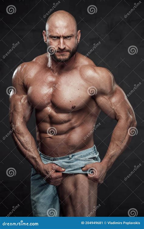 Serious Guy With Naked Torso Pulls His Shorts Showing His Leg In Studio Stock Image Image Of