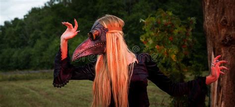 Blonde In Crow Mask Poses In Nature Near Old Tree Stock Photo Image
