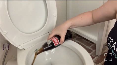 A Person Is Pouring Beer Into A Toilet