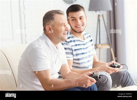 Mature Man Playing Video Game With His Son At Home Stock Photo Alamy