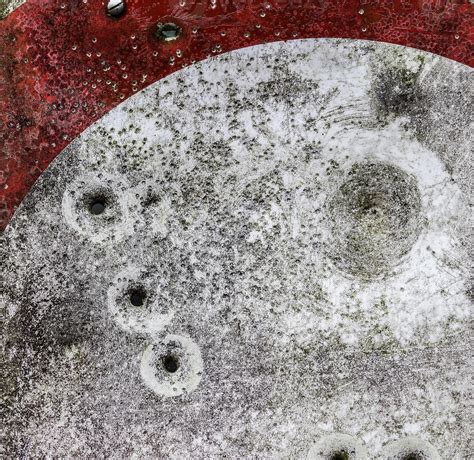 Detailed Close Up Of Bullet Holes From Gun Shots In A Traffic Sign