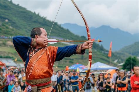 Premium Photo A Man Holding A Bow And Arrow In Front Of A Crowd