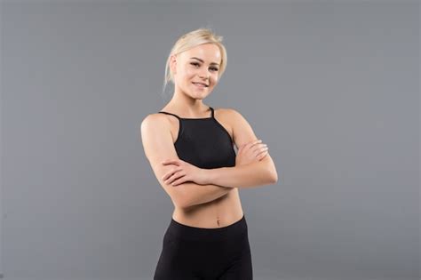 Jeune Fille Blonde Fit Sportive Femme En Vêtements De Sport Noir Démostrate Son Fort étirement