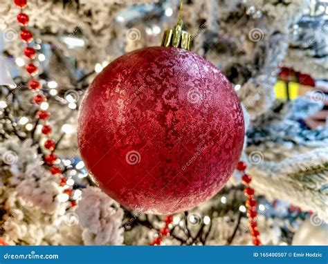 Red Ball Ornament Hanging On A Holiday Christmas Tree As Home