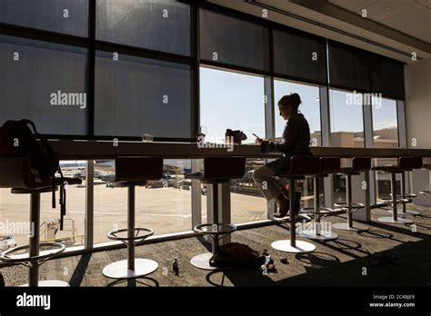 A Mature Woman Female Executive Seated Using A Laptop In An Airport Departure Lounge Stock