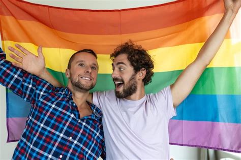 Dos jóvenes amantes gay mirándose cariñosamente dos jóvenes amantes masculinos de pie juntos