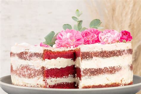 Red Velvet Naked Cake With Fresh Roses And Swiss Buttercream On Kitchen Countertop Stock Photo
