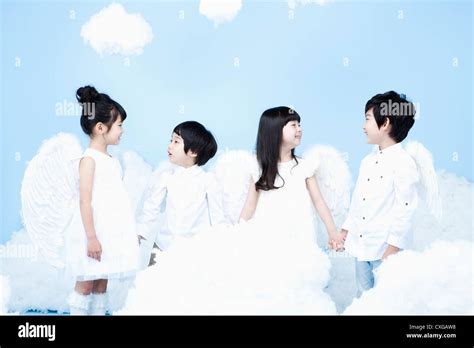 four kids with looks of angels on the clouds Stock Photo - Alamy