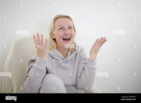 Happy Mature Blonde Lady Sitting On Couch Holding Video Call With Friends Head Shot Close Up