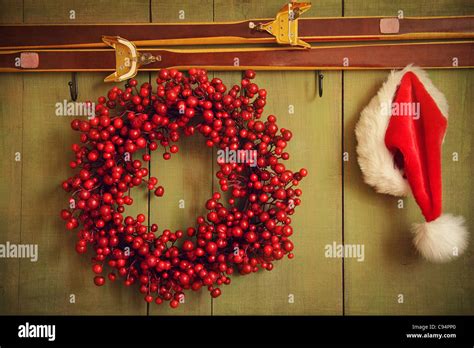 Christmas Wreath With Santa Hat Hanging On Rustic Wall Stock Photo Alamy