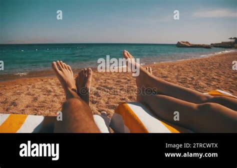 Legs Of Couple People Lying On Beach Sun Lounger Near The Red Sea Stock