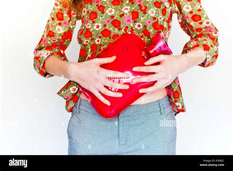 Woman Using A Hot Water Bottle On Her Belly To Releive Abdominal Pain Stock Photo Alamy