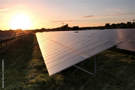 Sonnenkollektoren In Einem Solarpark Bei Sonnenuntergang Stock Photo