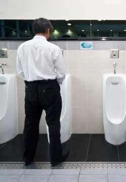 남성이 화장실에서 소변을 보지 못하도록 한 표지판이 있다