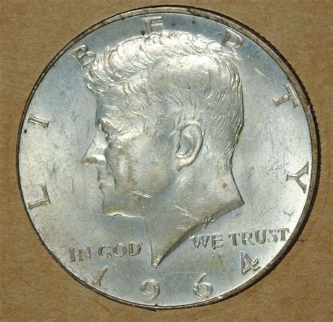 Half Dollar. The half dollar is the United States’ 50-cent coin. The person on the obverse (heads) of the half dollar is John F. Kennedy, our 35th president. He’s been on the half dollar since 1964. The design on the reverse (tails) is from the Presidential Seal. It shows an eagle holding an olive branch in its left talon and 13 arrows in .... 