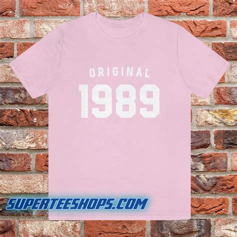 Description. Ships on June 14th, 2022. White 1989 t-shirt with powder blue "1989" and "T.S." printed on front chest. 100% cotton Depiction of this product is a digital rendering and for illustrative purposes only. Actual product detailing will vary. Taylor Swift® ©2022 TAS Rights Management, LLC Used By Permission.. 