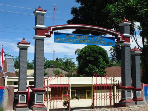 Gapura sekolah terbaik Menanjak jalan masuk sekolah melewati gapura, nampak gedung kelas bercat kombinasi hijau, putih, dan abu-abu