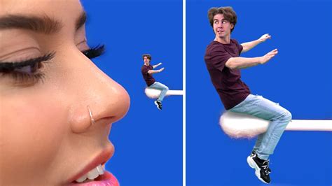 Giant woman licks tiny man Summer :Portrait of young women playful standing isolated over blue background while blowing bubble with chewing gum