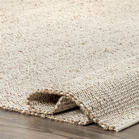 Helton handmade rug  It's handmade from 100% jute, and it showcases a circular, braided motif that complements any coastal-inspired space