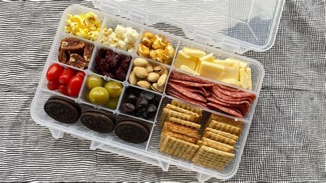 Snacklebox  Next, carefully add pickles or olives to their plastic-wrapped areas