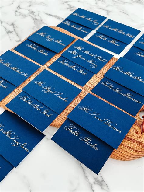 calligrapher escort cards Place cards and escort cards don’t have to be made using paper – most calligraphers are able to write guests’ names on alternative materials, such as ginko leaves, seashells, and even fruit: {image via Laura Hooper Calligraphy} {photograph by Rachel Whiting Photography via It’s Mary Ruffle} {image from Country Living via ritzy bee}The elegant escort cards were displayed in custom-made wooden place card holders and handwritten by Paperfinger Calligraphy in Brooklyn, NY