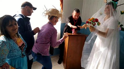 casamento na roça narrado  Chão em tons ocres, com manchas quadrangulares mais escuras; ao fundo, dois morros sugeridos na linha do horizonte, um de cada lado dos noivos