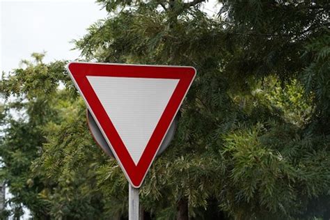 red and white triangular sign at an intersection  look both ways as you cross the intersection 3