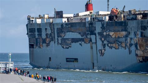 A car-carrying ship that burned for a week on the North Sea is towed to a Dutch port for salvaging