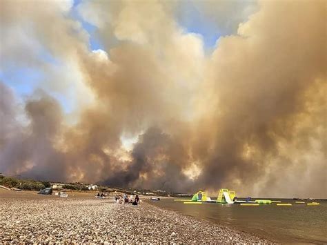 A wildfire is raging out of control on the Greek island of Rhodes, forcing tourist evacuations