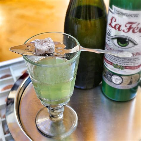 Absinthe drink recipe. Add ice and shake again until well-chilled. Fine-strain into a Collins glass and allow to stand for a minute so the frothed egg white settles at the top of the drink. Using a straw or bar spoon handle, make a small hole in the middle of the froth and slowly pour the soda water into the glass. Garnish with a mint sprig. 