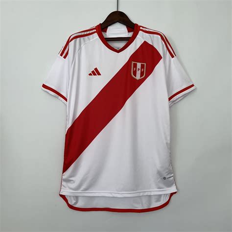 Adidas peru. The Peru 2023 adidas home jersey sticks with tradition via its white base and front and back red sashes. The v-neck shirt is detailed with red at its neckline, shoulders, flanks, and waistline. Peru’s 2023 away kit is mainly red with a series of small, dark gray trapezoids on its front and lower back. The shapes are arranged to create ... 