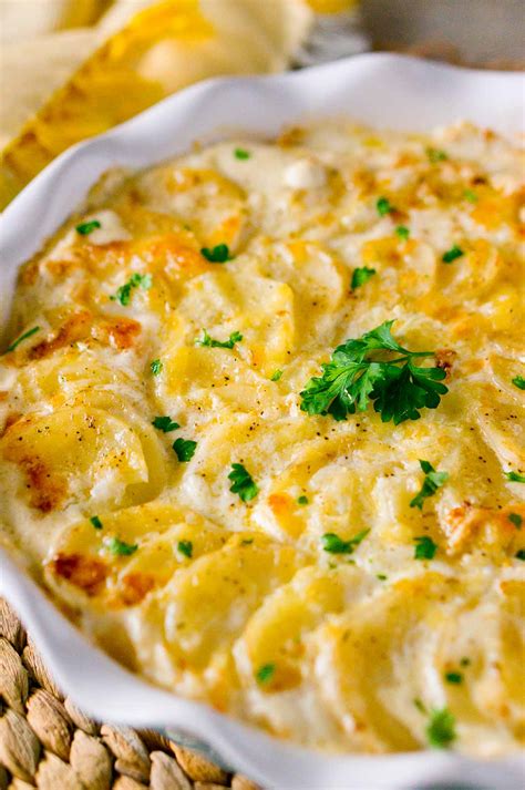 Layer half the potatoes in the dish and sprinkle with half the cheese then top with remaining potatoes. Whisk together sour cream, cream and 1 tsp salt. Pour cream mixture over potatoes. Tap dish on counter to settle ingredients and pop any air bubbles. Top with remaining cheese. Bake for one hour and fifteen minutes or until browned and tender.. 