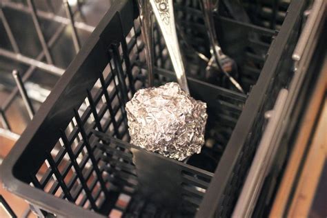 Aluminum foil in dishwasher. Choose a plastic or glass container that will accommodate your silver pieces. Line the bottom of the container with a piece of aluminum foil, shiny side up. Psst: Find more uses for aluminum foil. Step 2: Layer with baking soda and salt. Sprinkle baking soda and salt across the bottom. Gently shake the pan to distribute evenly. Step 3: Add ... 