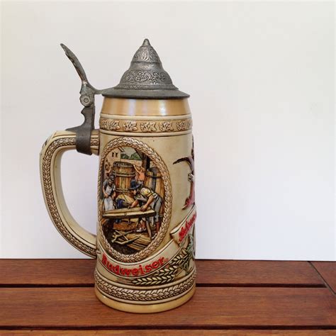 It should be noted that Ceramarte made at least two (and perhaps more) steins with the same central theme, but differing in several respects from the versions sold by Anheuser-Busch. The easiest way to distinguish the A-B steins is by the presence of the rectangular plate seen below the scene in all A-B examples. See also CS5 (unlidded version).. 