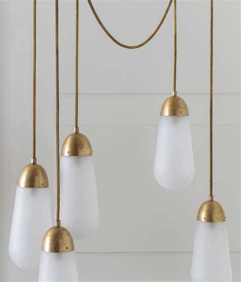 Apparatus lighting. METAL : The slip-cast porcelain forms of the Lantern series float along a rigid brass structure. their glow is punctuated by finely incised fluting, connecting to the most essential element of historical lanterns - light passing through a delicate protective form. Repeating spheres act as a counterpoint to the sizable shades. 