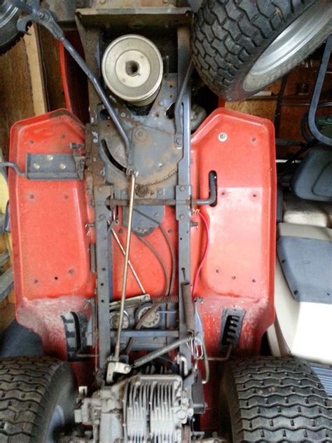 Pull off the mower deck. Lower the mower deck to its lowest position. Disengage the cutting blades. Roll the blade belt off the engine pulley and release the belt from the belt keepers. Remove the front lift link support retaining pin and washer, and then detach the support from the deck. Remove the left suspension arm retaining clip and washer.. 