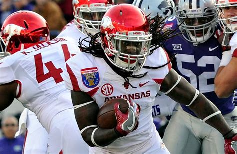 Kansas running back Devin Neal (4), offensive lineman Earl Bostick Jr. (68) and quarterback Jalon Daniels (6) and an Arkansas defender reach for the ball during the first half of Liberty Bowl NCAA college football game Wednesday, Dec. 28, 2022, in Memphis, Tenn. Arkansas recovered the ball.. 