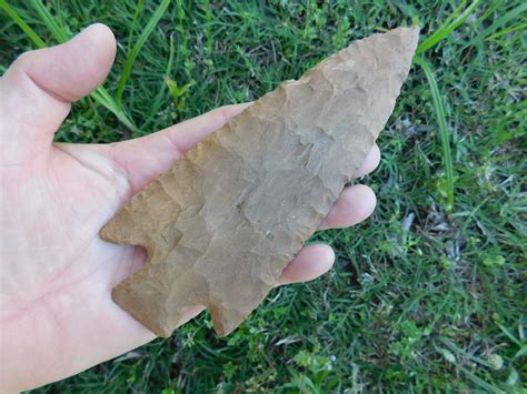 Arrowheads chert. Cluster: Savannah River Cluster. This is a medium to large triangular stemmed point with a flattened to elliptical cross section. The blade is primarily excurvate, but may curve at the tip and have parallel edges one half of the blades length. The shoulders may vary from horizontal to having an upward slope. 