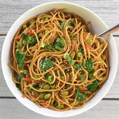 Asain noodles. Instructions. Preheat a skillet on high heat with canola oil. Add shredded carrot to the skillet and cook until the carrots soften. Remove from skillet and set aside. Add sesame oil to the same skillet and fry noodles until they get crispy edges. Add carrots back to the noodles and add in the chopped green onions. 